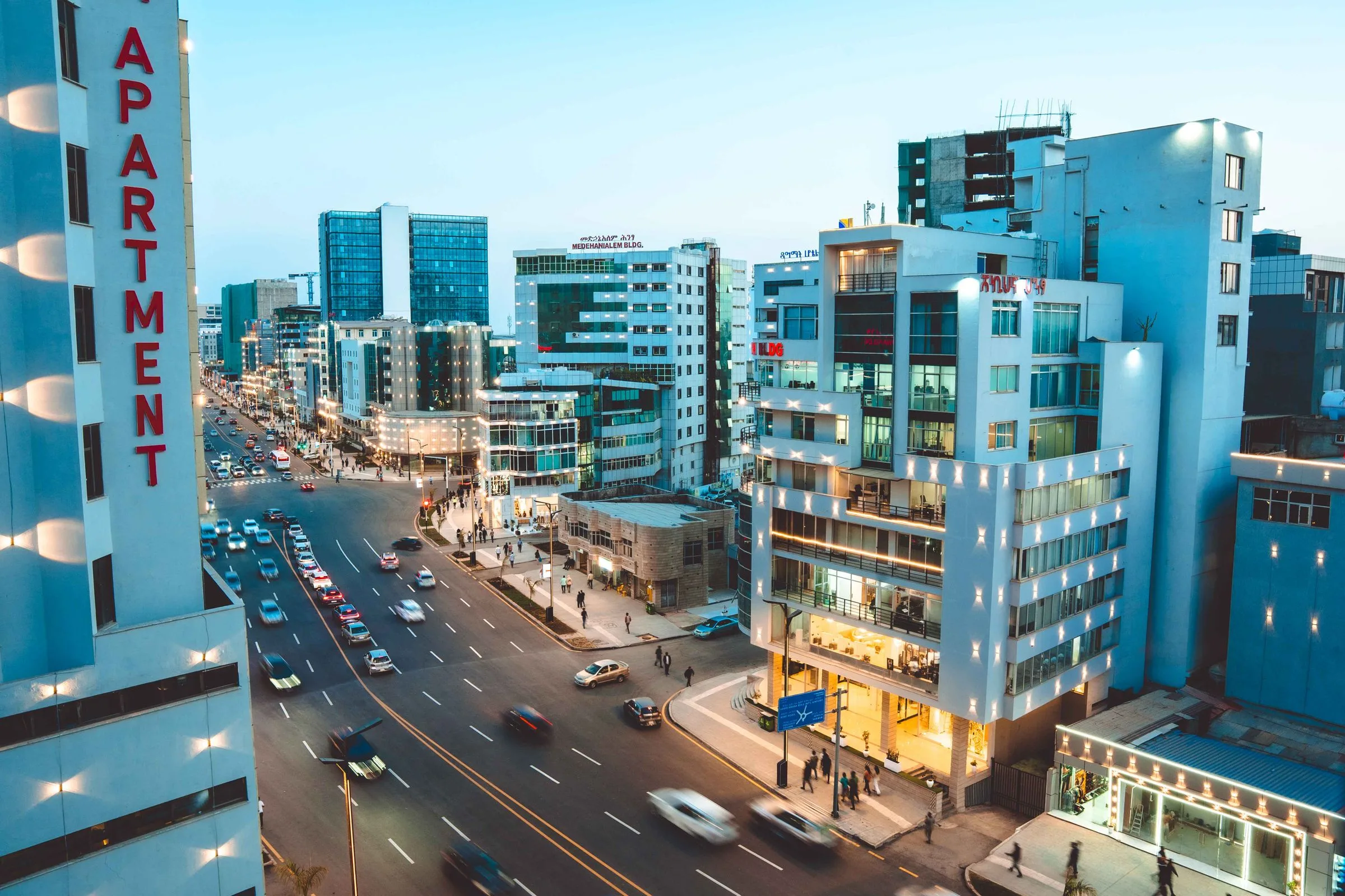 Evening traffic on a main road in Addis Ababa with lit buildings